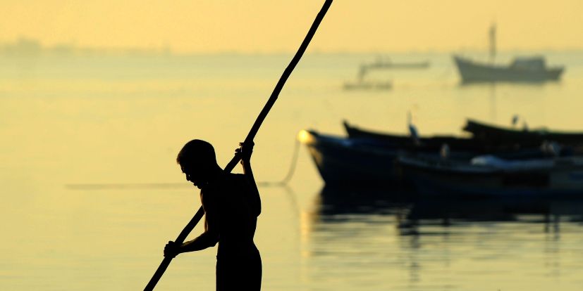 Un pescador de Sri Lanka rema desde su barco a lo largo de la costa en...