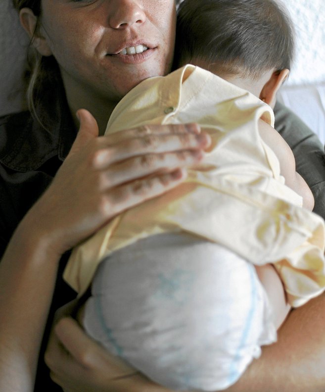 Una madre sostiene a un recién nacido sobre su hombro
