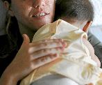Una madre sostiene a un recin nacido sobre su hombro