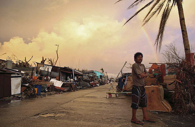 Un hombre permanece en una zona devastada por el tifn Haiyan en...