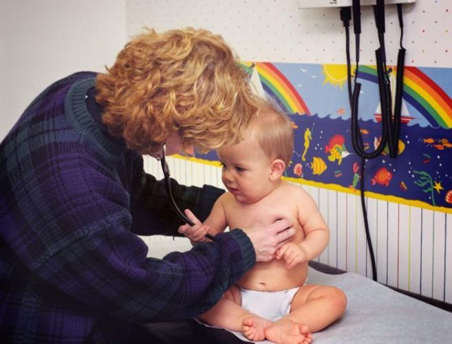 Un mdico atendiendo a un beb en la consulta de Urgencias.