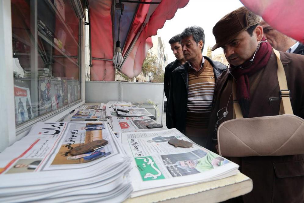 Iranes observan las portadas de los peridicos que informa del...