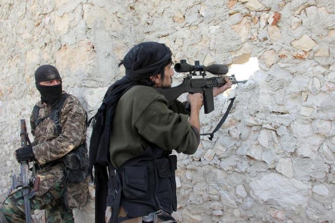 Milicianos rebeldes disparan contra las fuerzas de Asad, a travs de...