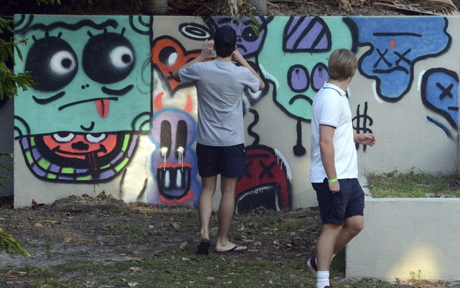 Dos jóvenes fotografían el muro pintado por Bieber.