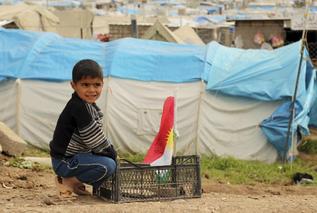 Un nio sirio juega con una bandera del Kurdistn.