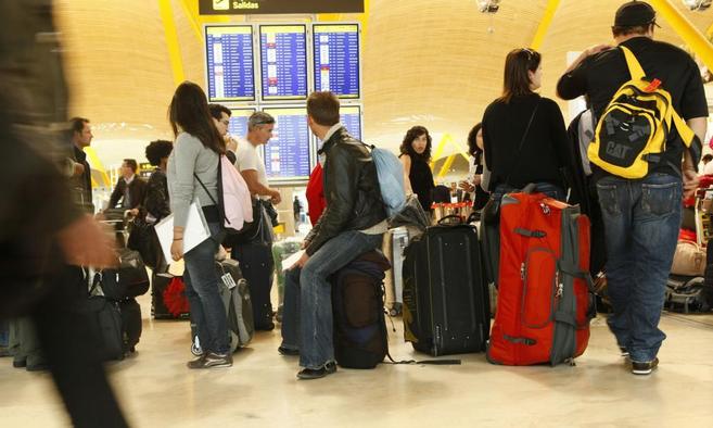 Viajeros esperan un vuelo hacia Londres en la terminal 4 del...