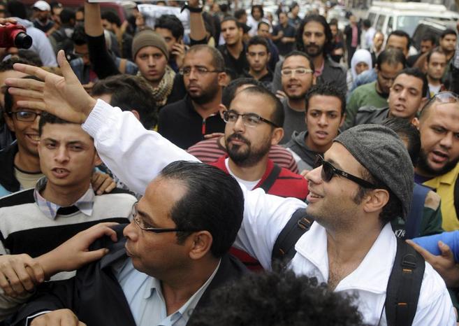 Ahmed Maher, de blanco, saluda a sus seguidores, antes de comparecer...
