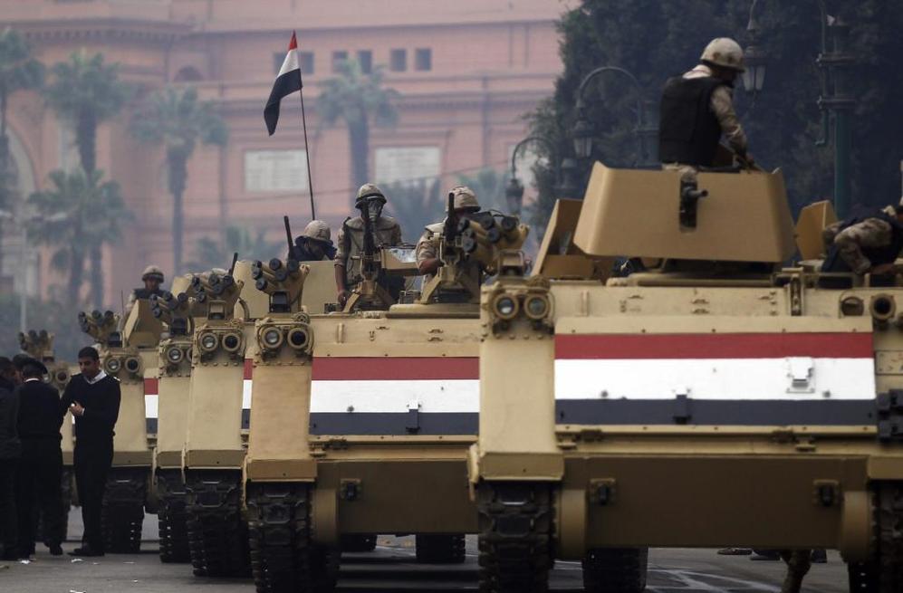 Soldados egipcios montados sobre tanques llegan a la plaza Tahrir para...