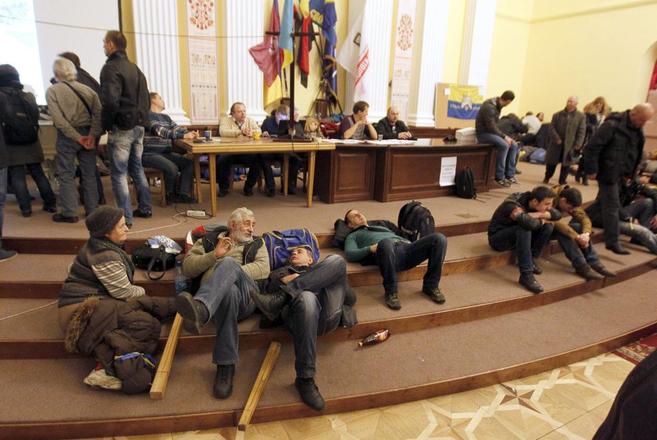 Varias personas descansan en el Ayuntamiento de Kiev.