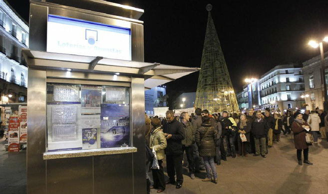 Largas colas para comprar lotera en el centro de Madrid.