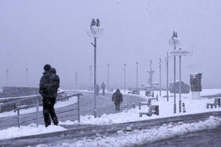 Transentes bajo la nevada en Gdynia, Polonia.