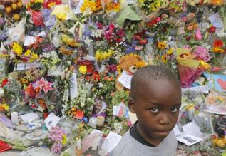 Un nio ante las flores colocadas en la casa de Mandela.