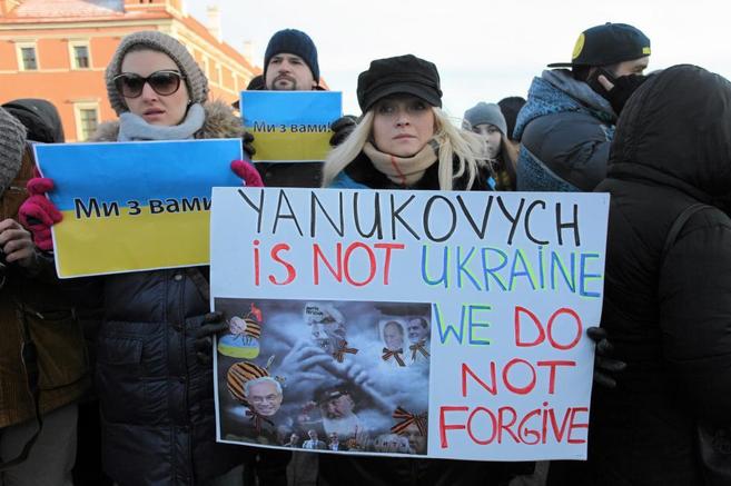 Detractores del presidente Yanukovich muestran pancartas en su contra.