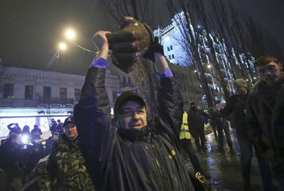 Un manifestante sostiene el puo de la estatua de Lenin derribada este domingo en Kiev.