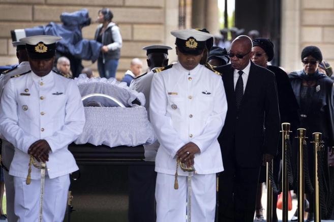 El presidente Jacob Zuma pasa ante los restos mortales del ex...