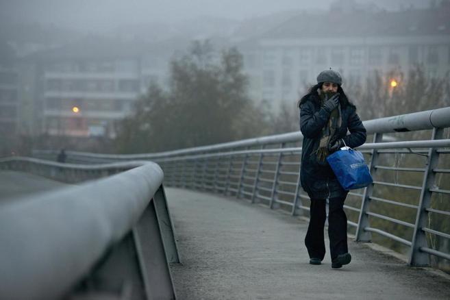 Una mujer se protege del fro en Ourense.