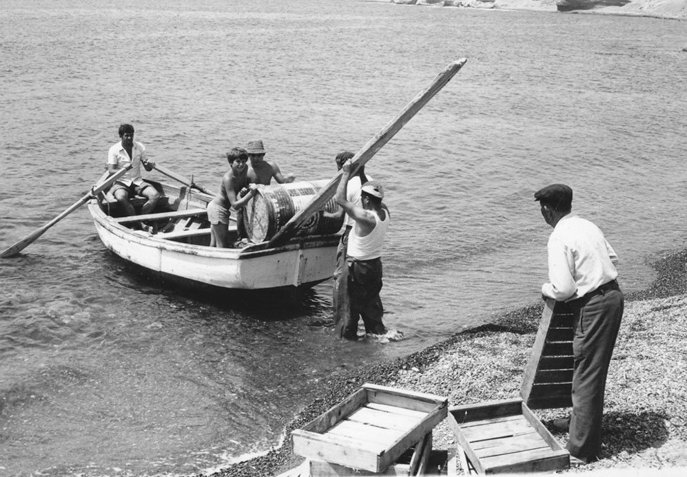 Industrias de la mar: unos mozos de Njar transportan un bidn procedente de un barco.