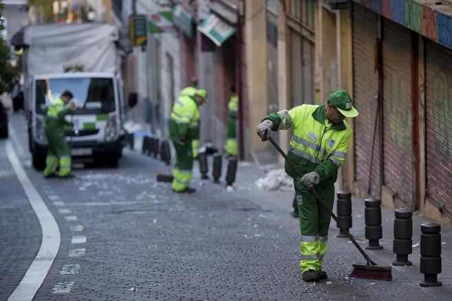 Un grupo de barrenderos limpian las calles de Madrid.