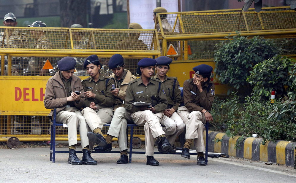 Mujeres polica se sientan junto a una barricada durante las...