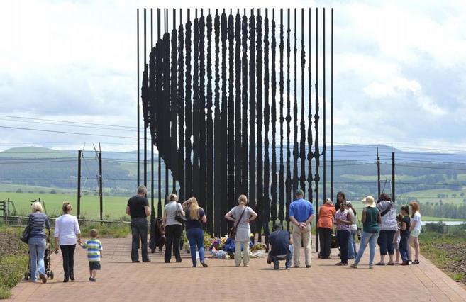 Turistas visitan una de las esculturas que recuerdan al fallecido...