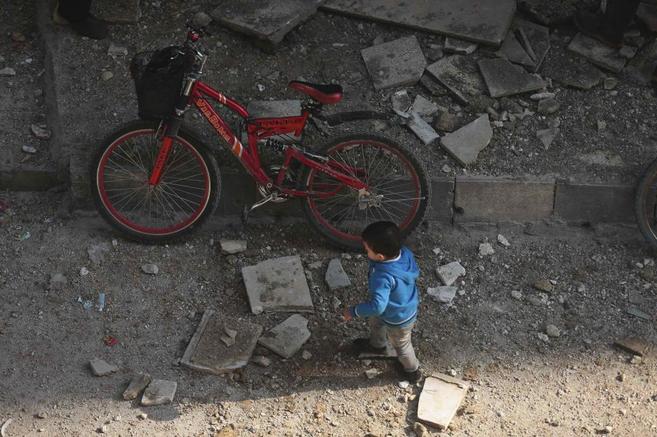 Un nio anda entre los desperfectos de otro bombardeo en Damasco.