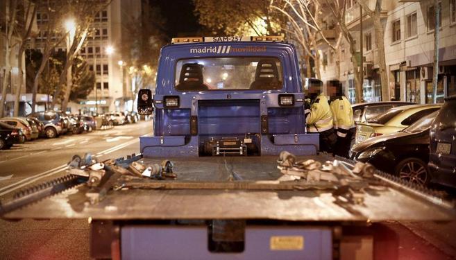 Una gra municipal retirando un coche en el centro de Madrid.