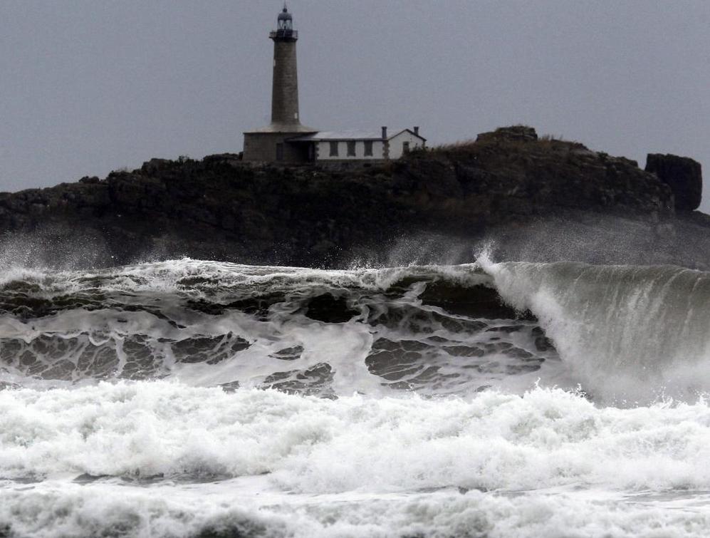Una ola rompe sobre la playa de Somo, en la baha de Santander,...