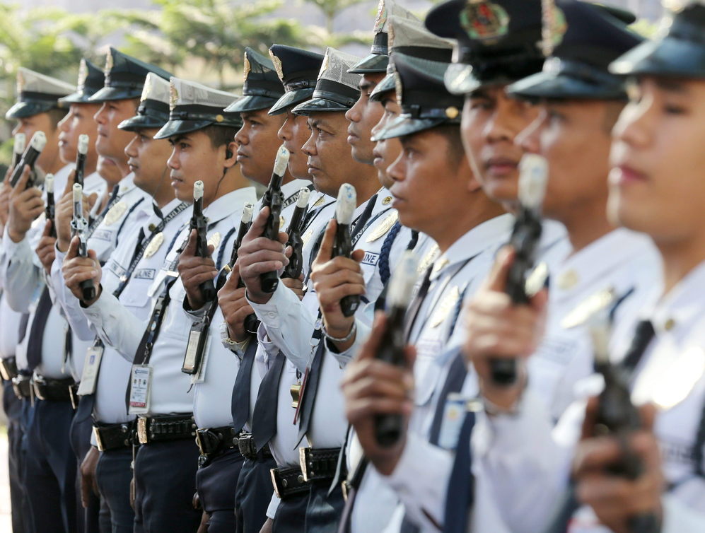 Agentes de seguridad filipinos durante una inspeccin, con las armas...