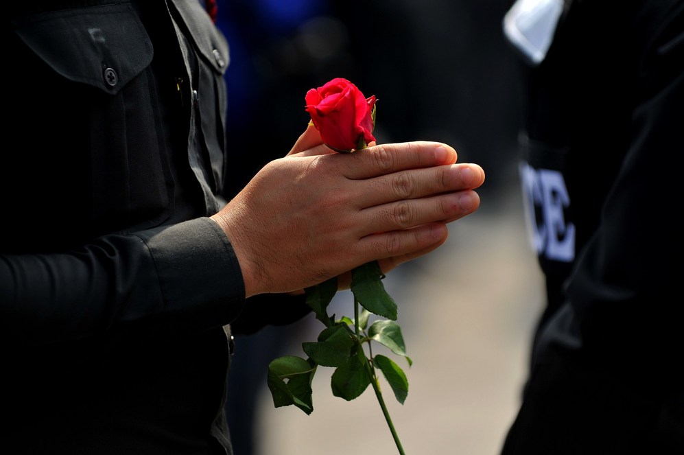 Un polica tailands sostiene una flor durante una protesta...