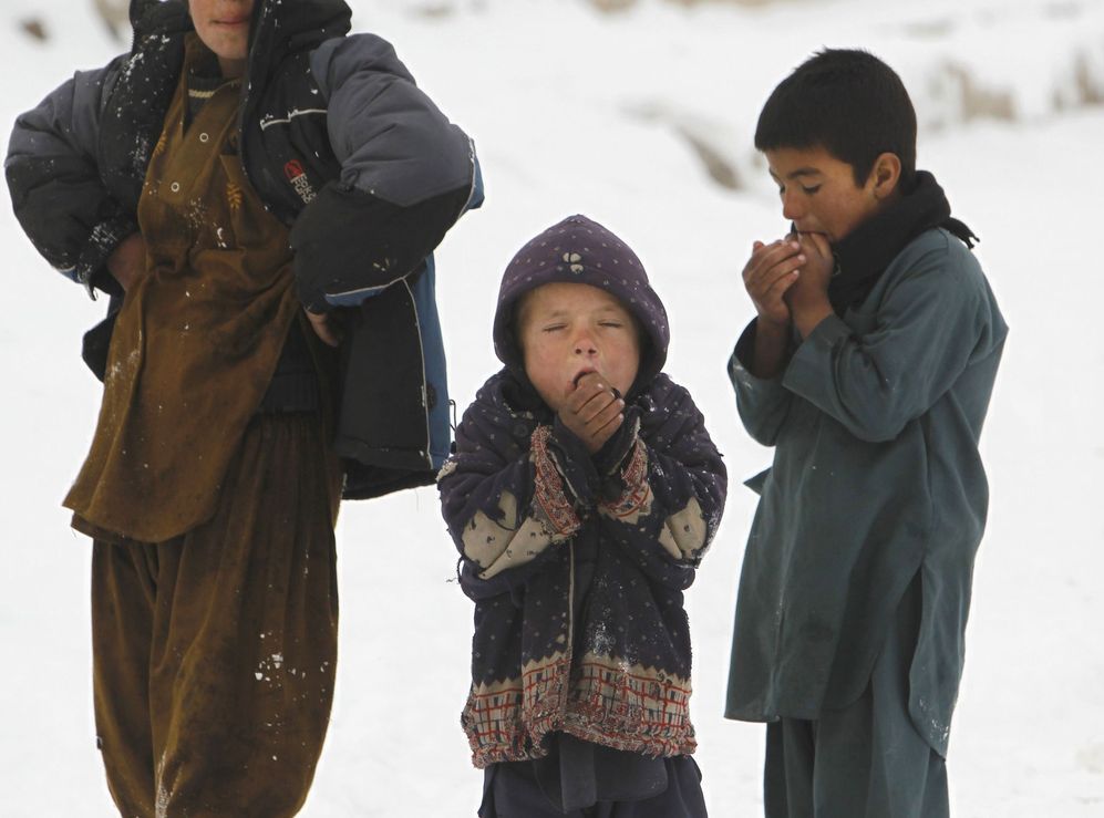 Nios en la nieve, fuera de su refugio en Kabul.