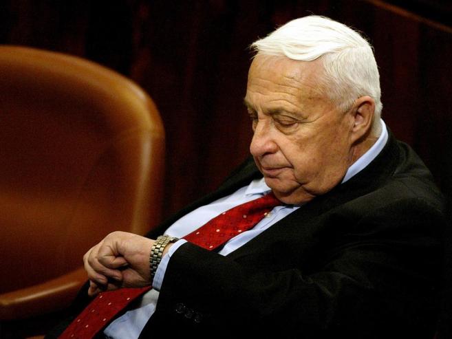 El ex primer ministro israel, Ariel Sharon, mira la hora en la...