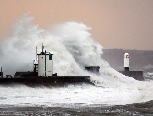Una ola gigante rompe en el paseo martimo de Prothcawl en Gales.