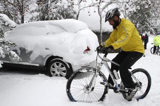 Un hombre intenta avanzar con su bicicleta sobre la nevada cada en O...