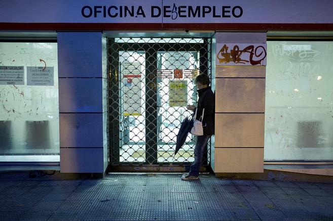 Una mujer espera a la apertura de una Oficina de Empleo en Madrid