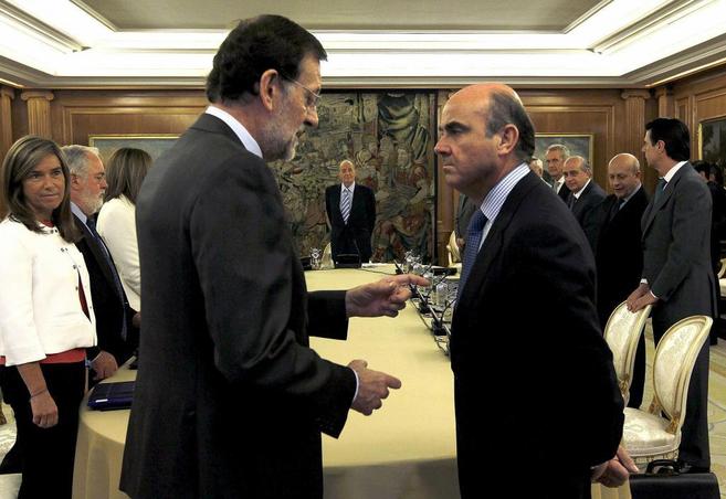 Mariano Rajoy charla con Luis de Guindos durante el Consejo de...