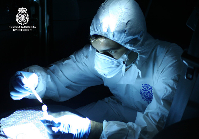 Un agente de polica cientfica trabajando con una muestra de ADN.