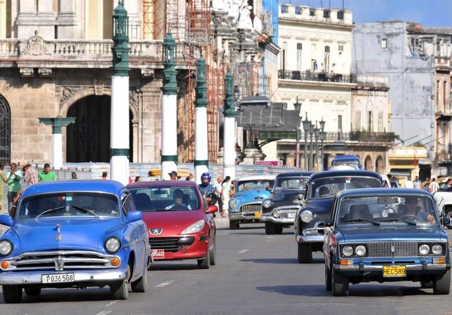 Varios coches circulan por una calle de La Habana.