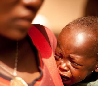 Un nio africano llora en brazos de su madre