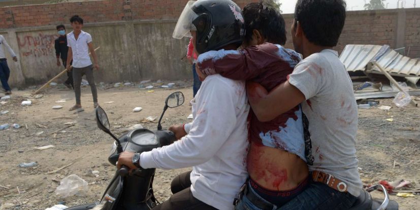 Trabajadores camboyanos transportan a un trabajador herido en un...