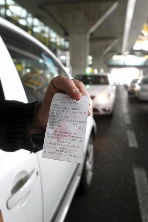 Un taxista de la T-4 muestra el ticket de la tarifa plana: 30 euros