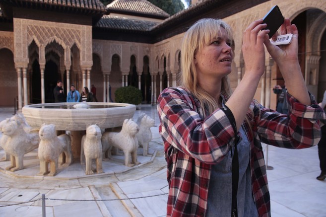 Una turista hace fotos en uno de los patios de la Alhambra.