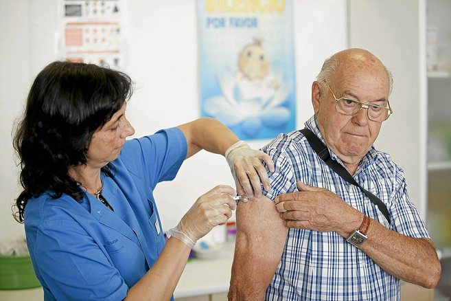 Un hombre recibe la vacuna contra la gripe.