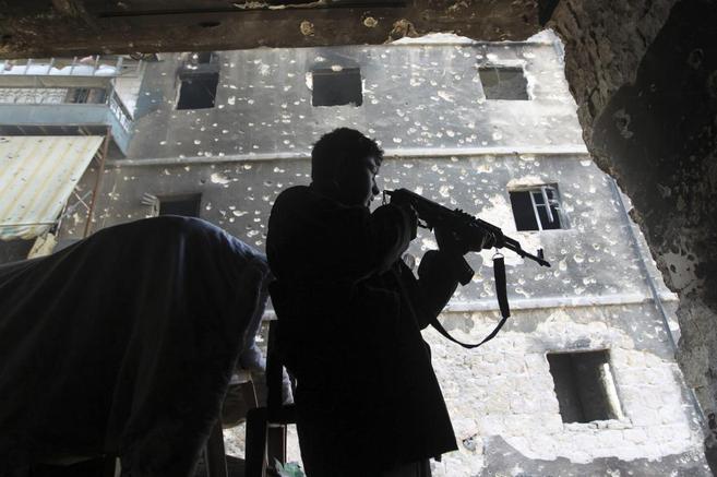 Un combatiente del Ejrcito Libre de Siria apunta con su arma en la...