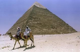 Dos egipcios en camello pasan ante la pirmide de Kefrn en Guiza,...