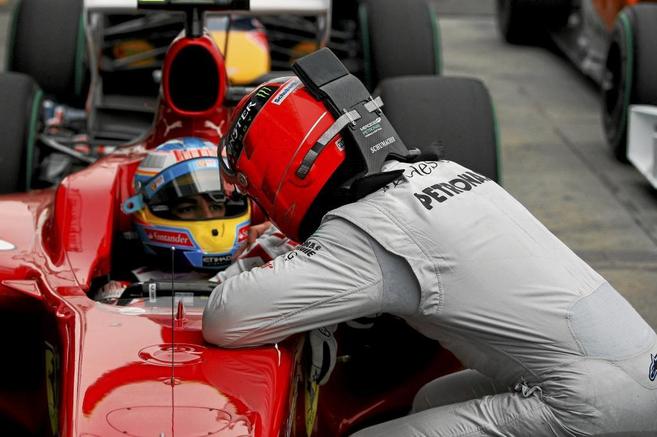 Michael Schumacher (GER) Mercedes GP habla con Fernando Alonso (ESP)...