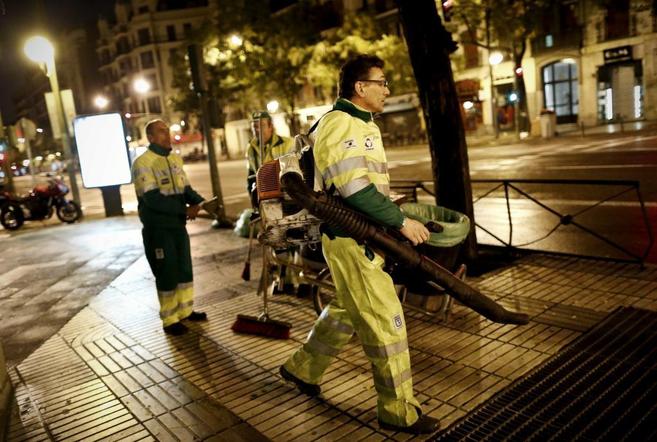 Tres operarios limpian las calles de Madrid, tras la huelga de...