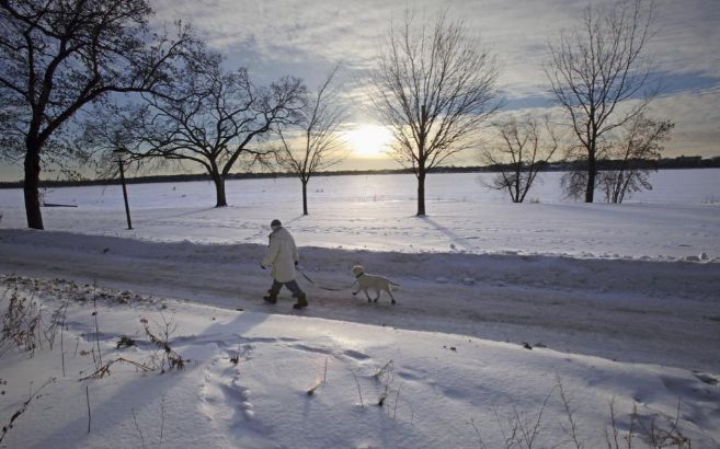 Un hombre pasea al sol en un paisaje nevado