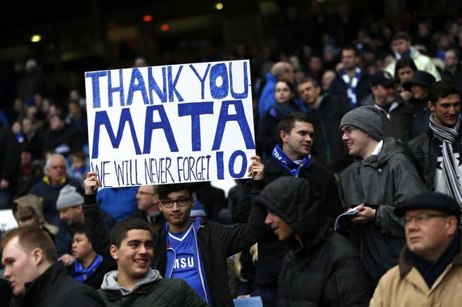 Un aficionado del Chelsea muestra una pancarta de agradecimiento a...