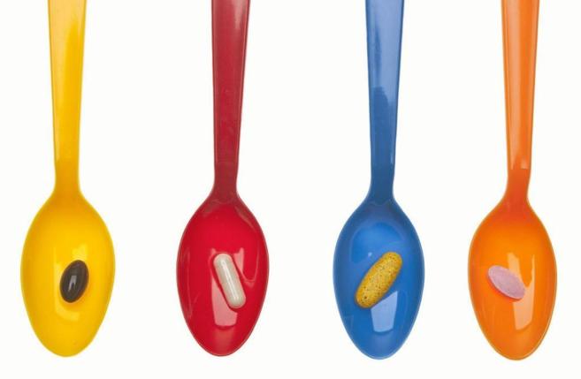 Varias pastillas en cucharas de colores