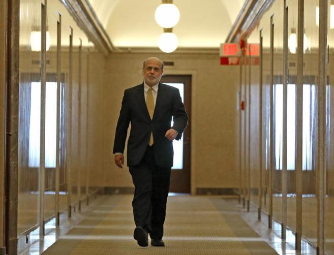 El ex presidente de la Fed, Ben Bernanke camina por las oficinas del...
